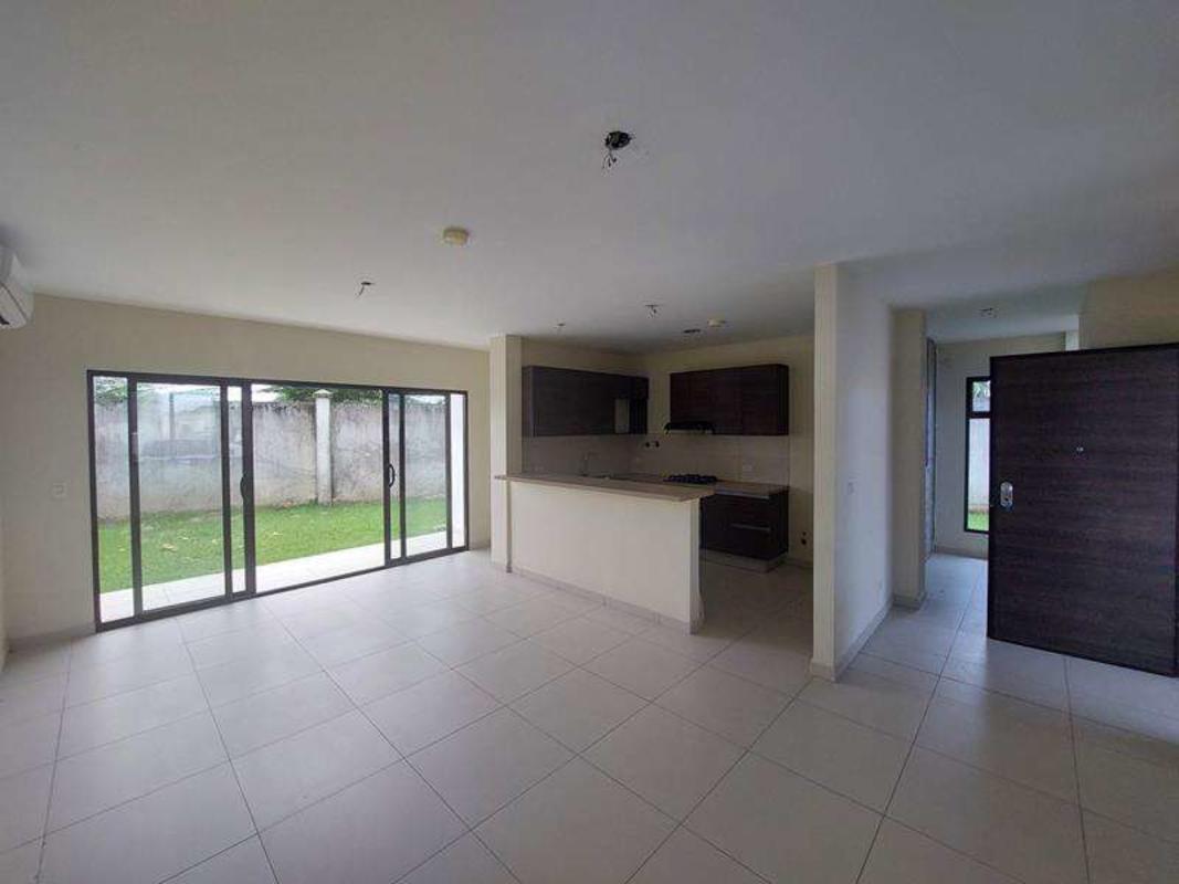 Living and kitchen open space with sliding doors to backyard in Costa Sur Village house Panama