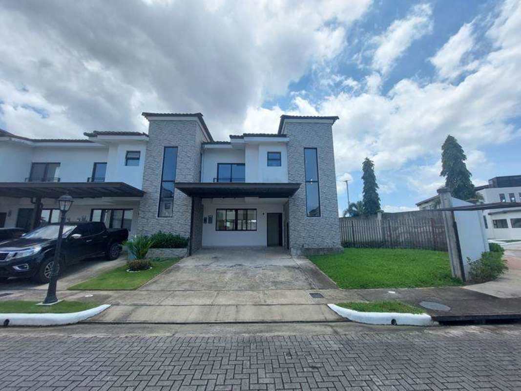Modern two-level house with stone accents, attached garage, and landscaped front yard in Costa Sur Panama