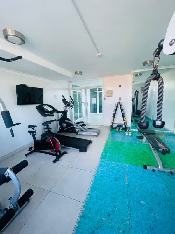 Equipped apartment gym with machines and blue padded floor in PH Albrook Residence Panama