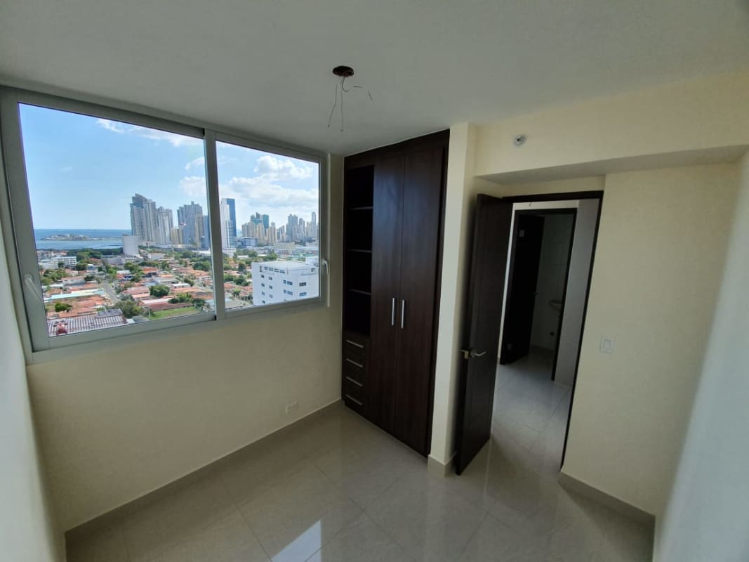 Spacious bedroom with floor-to-ceiling window offering panoramic Panama City skyline view in PH San Francisco Skyline