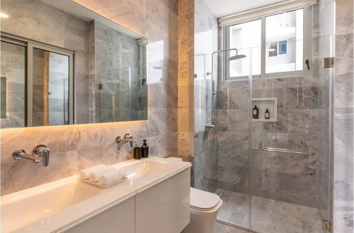 Bathroom with marble finishes, double sink vanity, glass enclosed shower in Santa María apartment Panama