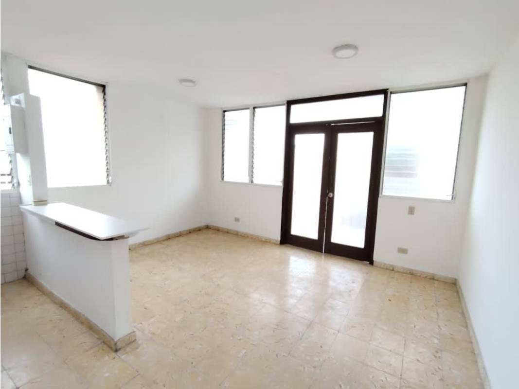 Compact kitchen with breakfast bar, louvered windows, and white cabinetry at PH Las Palmas San Francisco Panama City