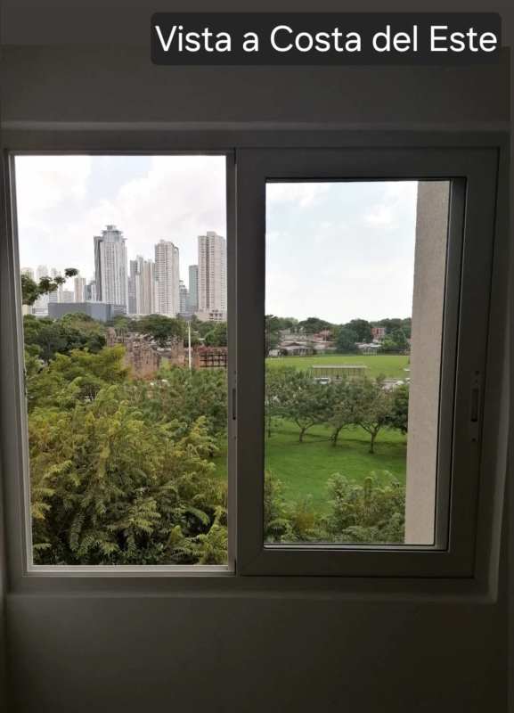 Panoramic city skyline and green areas view through window at PH Panama Viejo Residences Panama.