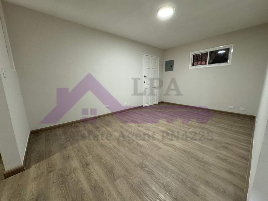 Bedroom with wood-like flooring large window and closet PH Loma de Miramar Panama