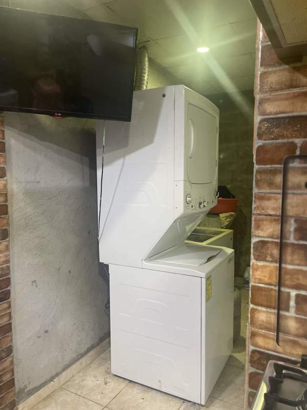 Laundry with washer dryer, TV, brick accent wall Parque Santa Lucía Tocumen
