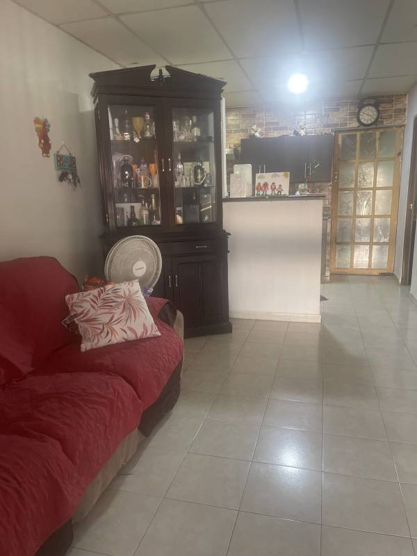 Living room with red sofa, tile floors, open to kitchen in Parque Santa Lucía Tocumen Panama City