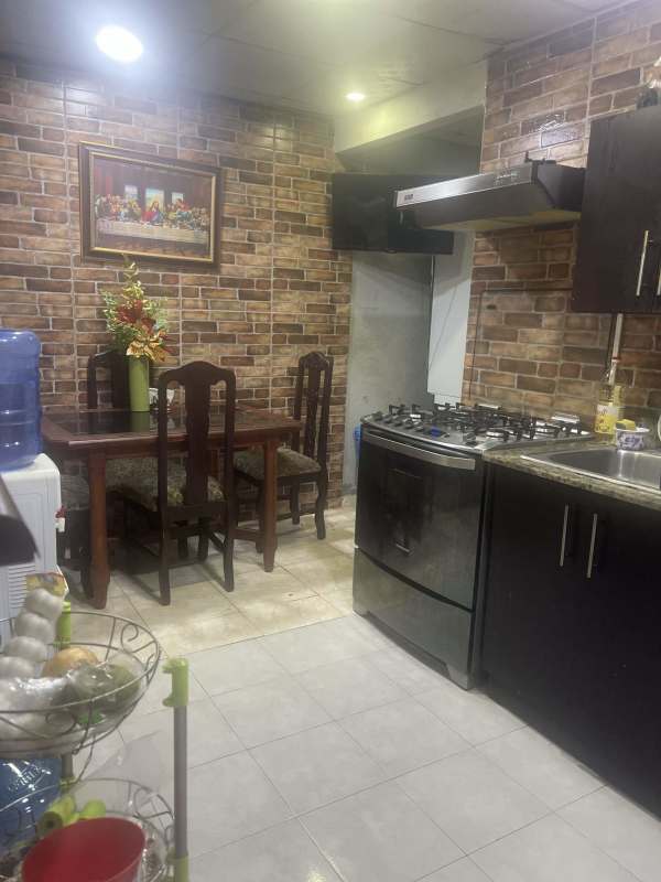 Kitchen and dining area with brick tile wall and wooden cabinetry in Parque Santa Lucía Tocumen Panama