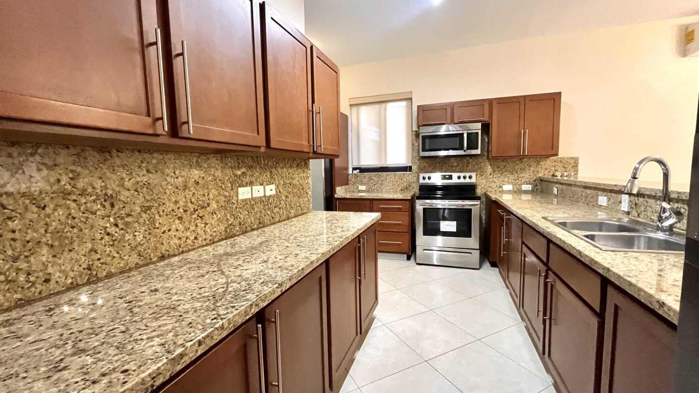 Granite kitchen with wood cabinets, stainless appliances, breakfast bar in PH Embassy Club Clayton