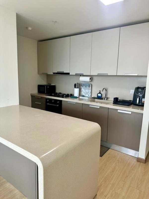 Open kitchen island modern cabinetry wood tone PH Coco del Mar Panama City apartment