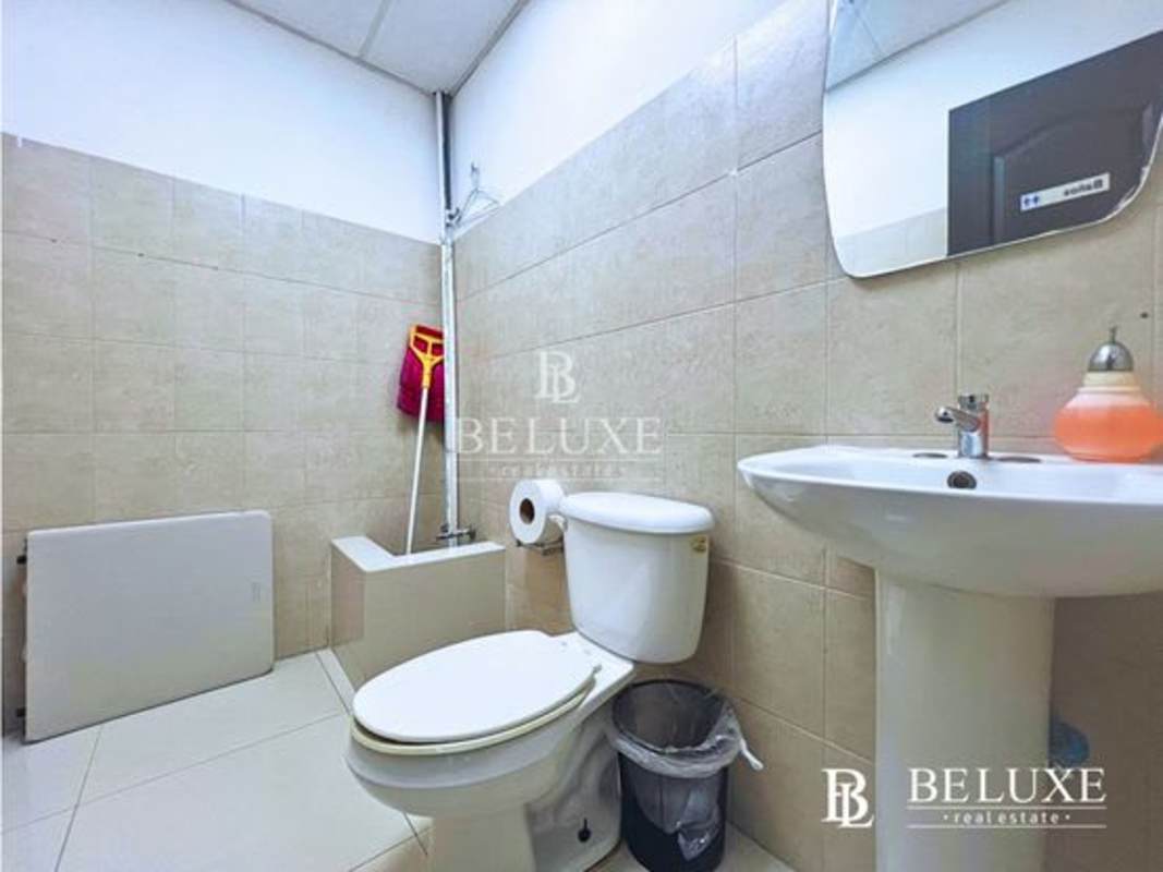 Functional bathroom with sink, toilet, mop and utilities in Torre USB office Panama City