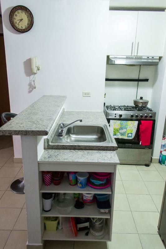 Compact kitchen with granite countertops, stove, bar in PH Roca Park Panama
