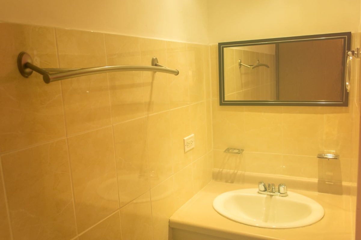 Bathroom with pink curtain, storage shelves and decor in PH Roca Park Panama