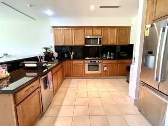 Modern kitchen with granite countertops, wooden cabinets and stainless steel appliances in Casa del Sol Buenaventura