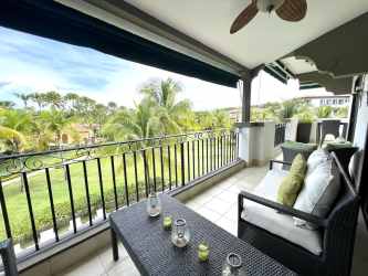Mediterranean-style covered balcony with lounge furniture overlooking pool and gardens at Casa del Sol Buenaventura