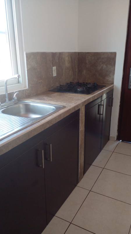 Compact kitchen with refrigerator and cabinets in Paseo del Valle Villa Lucre apartment