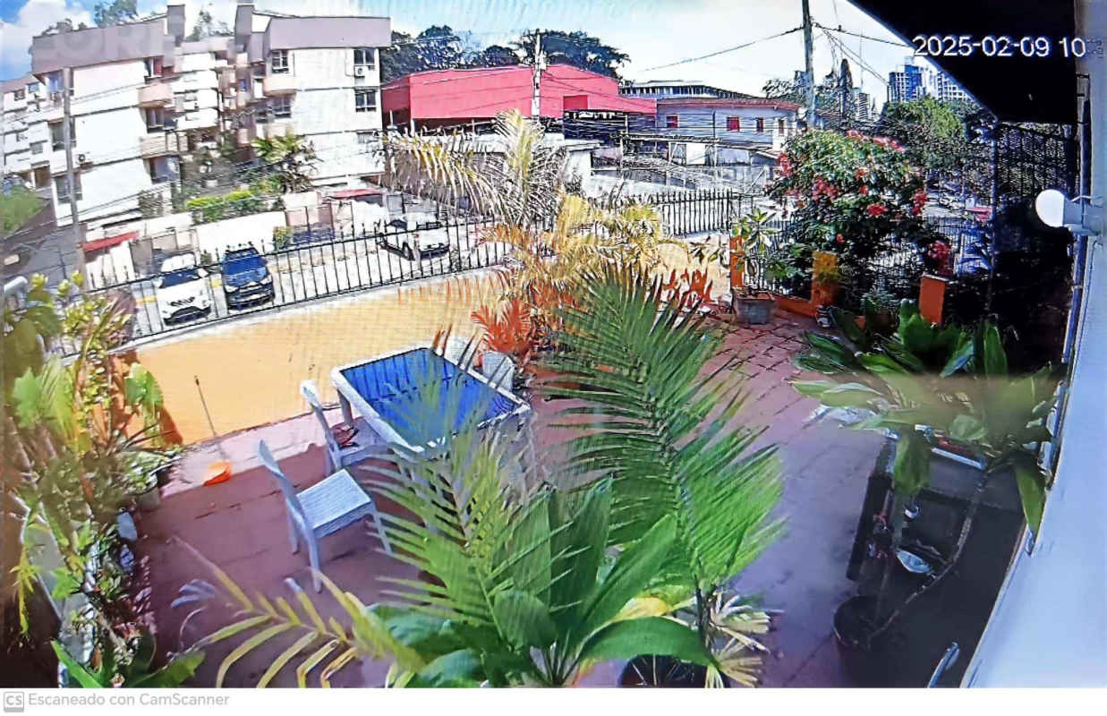 Rooftop city terrace with tables chairs lush plants overlooking skyline Residencia La Cresta Panama