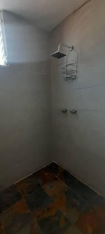 Modern bathroom with walk-in shower tile walls and small window PH Torre El Cangrejo Panama