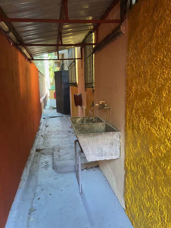 Covered outdoor utility space with laundry sink colorful walls Panama apartment