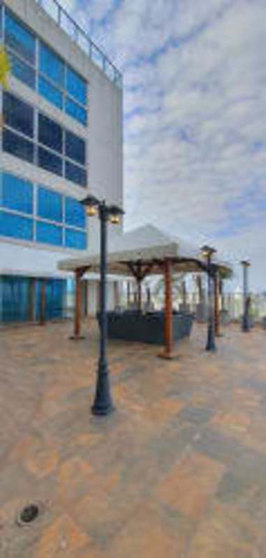 Outdoor patio with gazebo and multi-story glass facade tower at PH Oceanaire in Panama City