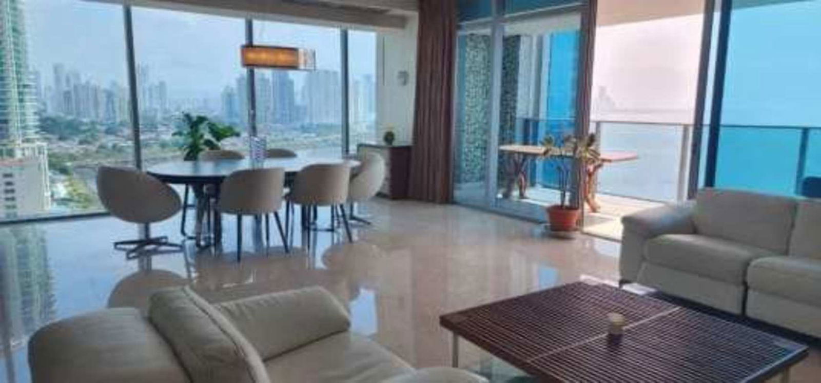 Modern living area with floor-to-ceiling windows, panoramic ocean and skyline views at Grand Tower Punta Pacifica Panama