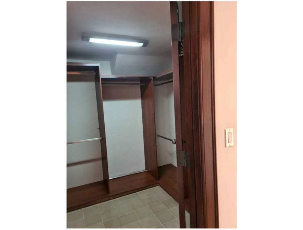 Double-height living room with loft, exposed stone wall and arched window in Casco Viejo Panama