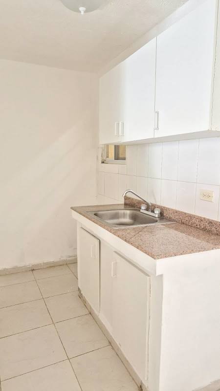 Minimalist kitchen with granite countertop white cabinets window PH Villas del Naranjal Pedregal Panama