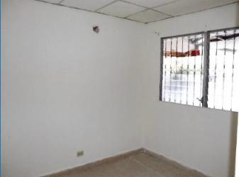 Empty room with white walls, security bars, tile floors, drop ceiling