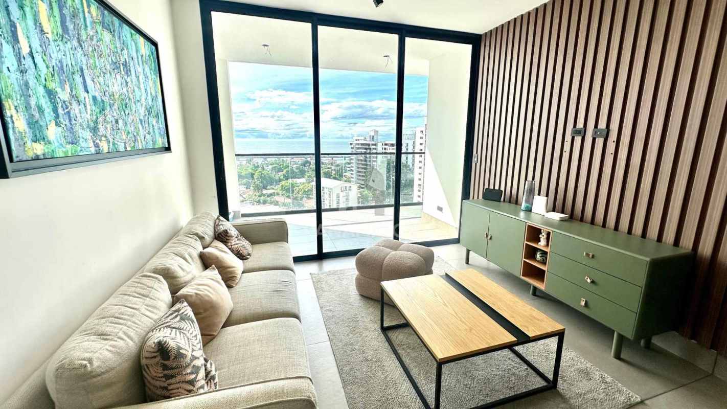 Spacious living area with access to balcony overlooking ocean and skyline Victory Wellness Panama City