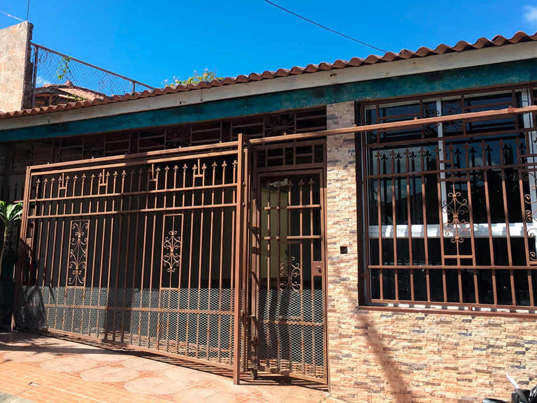 Exterior facade with brown gate, tiled roof Villa Zaita home for rent Panama
