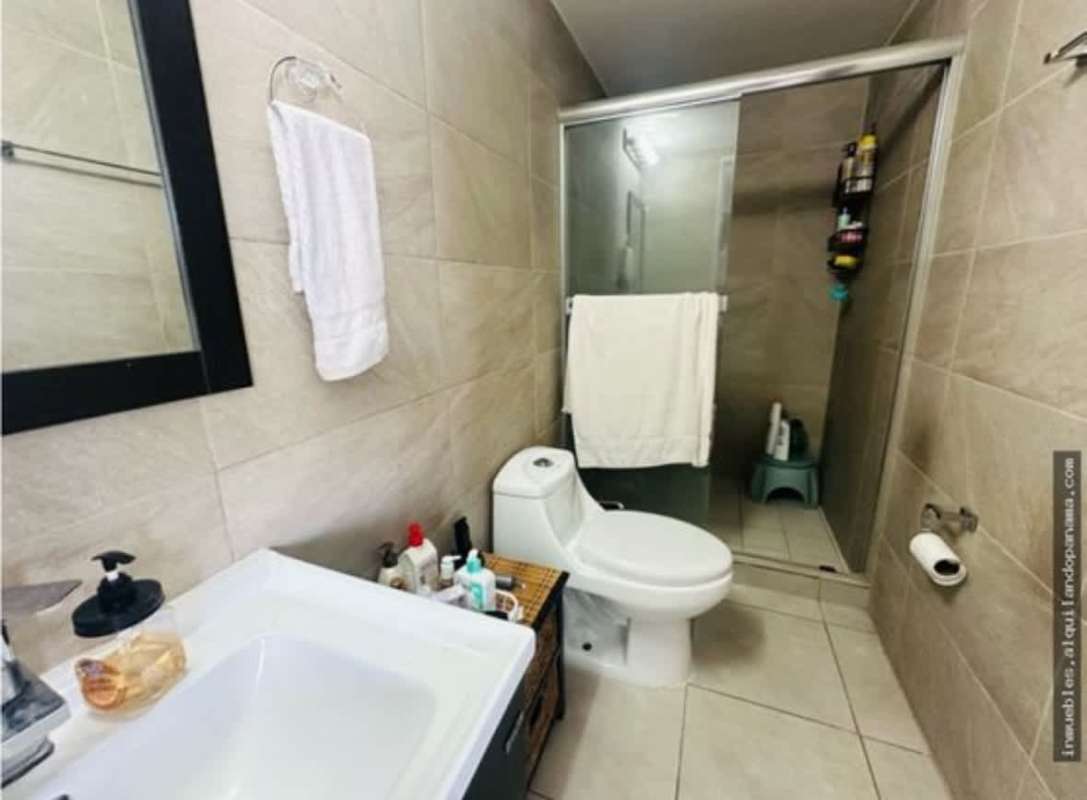 Modern bathroom with beige tiles, glass shower, and pedestal sink, apartment for rent PH Gaudi Panama