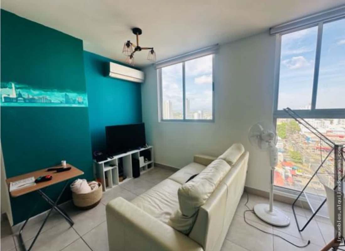 Contemporary living space with teal accent, cream sofa and large windows PH Gaudi Panama