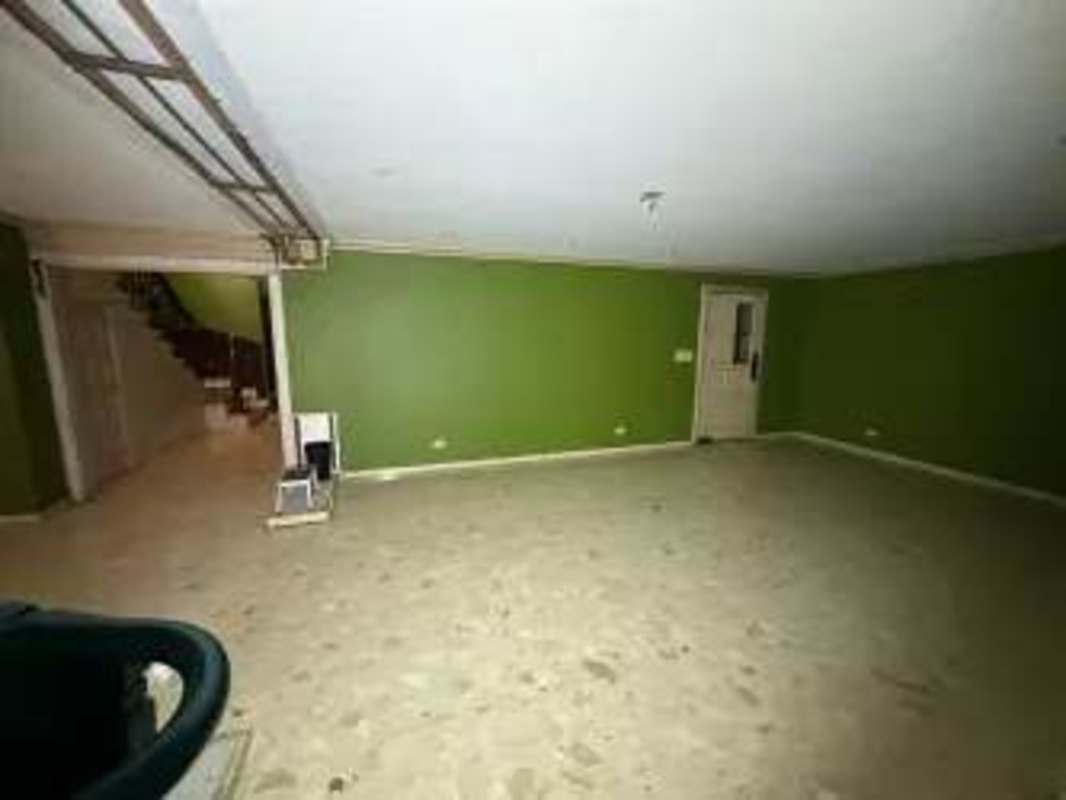 Bare basement space with green walls and stairs in rental house Obarrio Panama