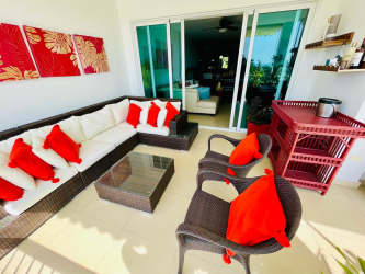 Dining room with glass table, open living area in luxury beach condo Panama