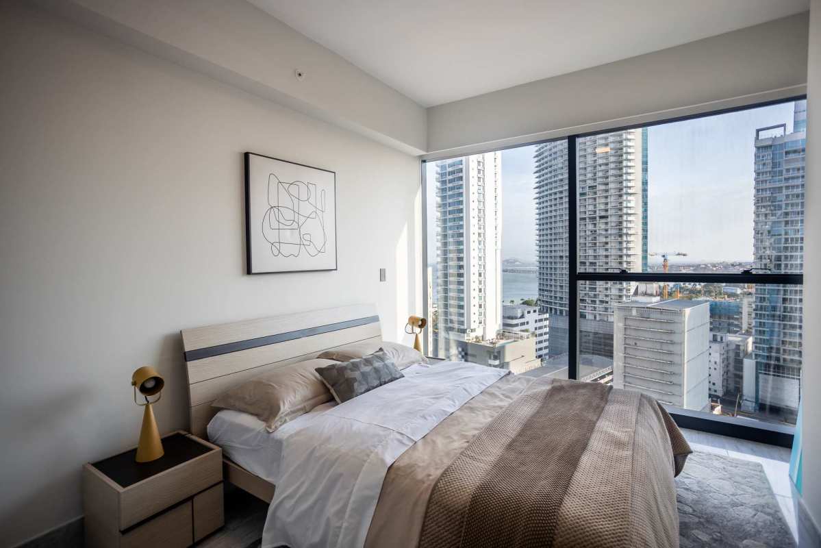 Bedroom with large windows, city skyline view and modern furnishings Nuovo by Armani Casa Panama