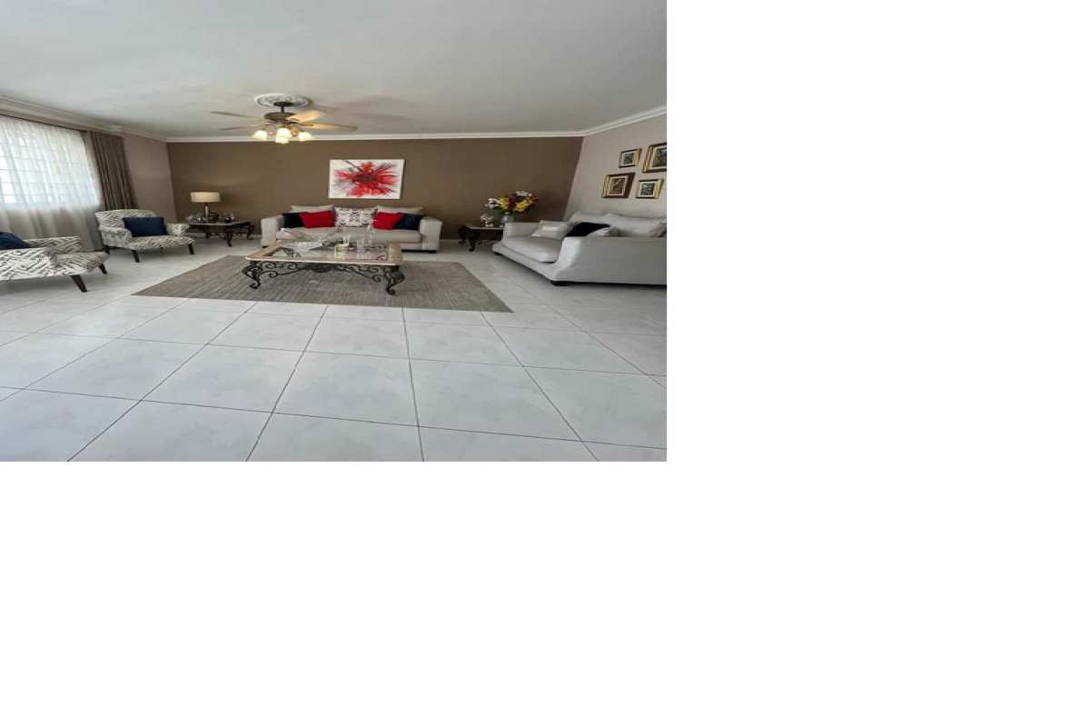 Contemporary living room with tile floors, large windows, sofas and ceiling fan in Villa de las Fuentes Panama
