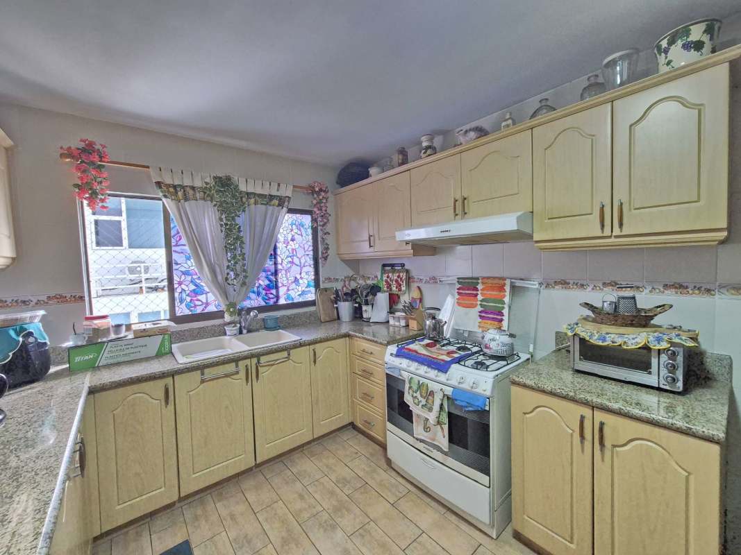 Traditional kitchen with granite countertops, gas stove, wooden cabinets in PH Agua Marina Coco del Mar