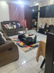 Dining space adjacent to living room with tile floors in Arraiján house