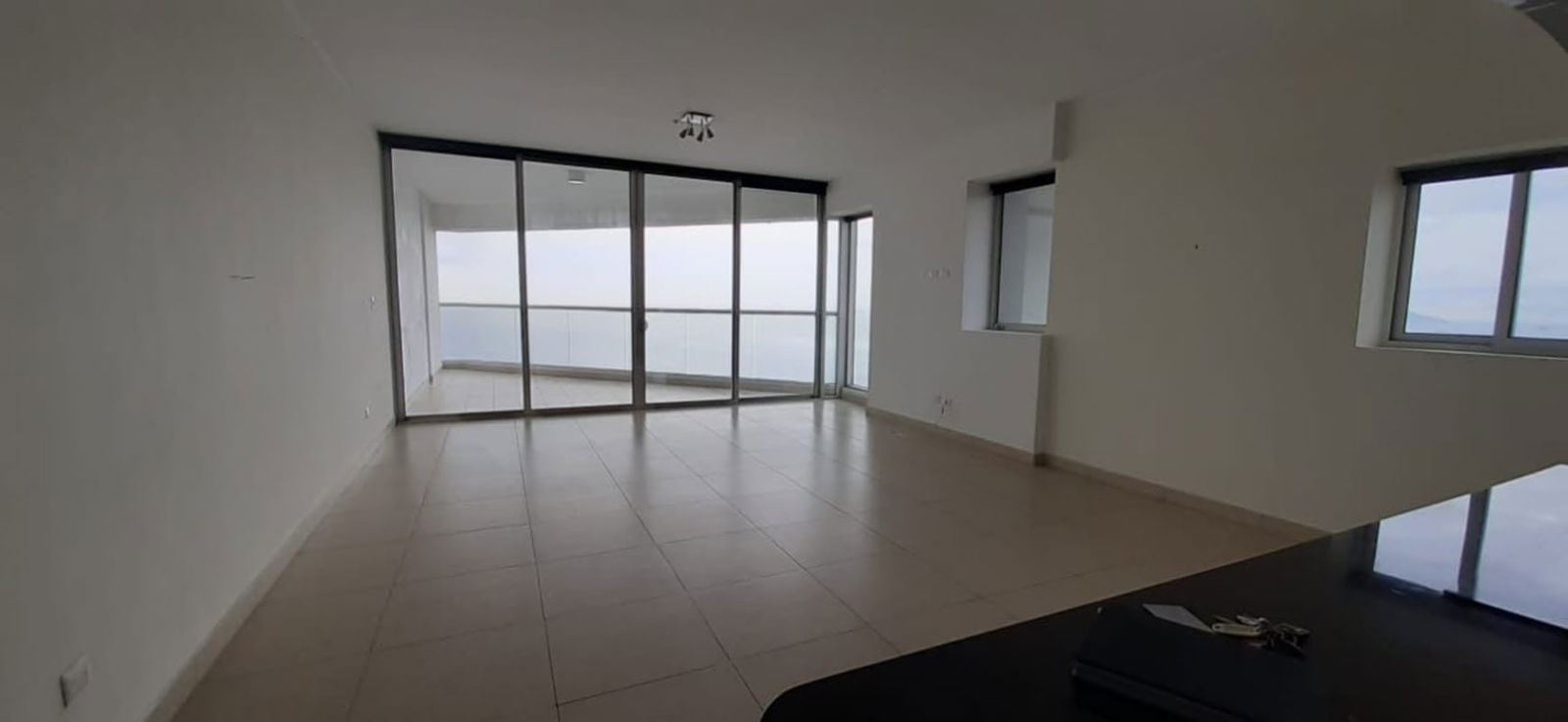 Modern spacious living room with floor-to-ceiling windows and bay view at PH Rivage Panama