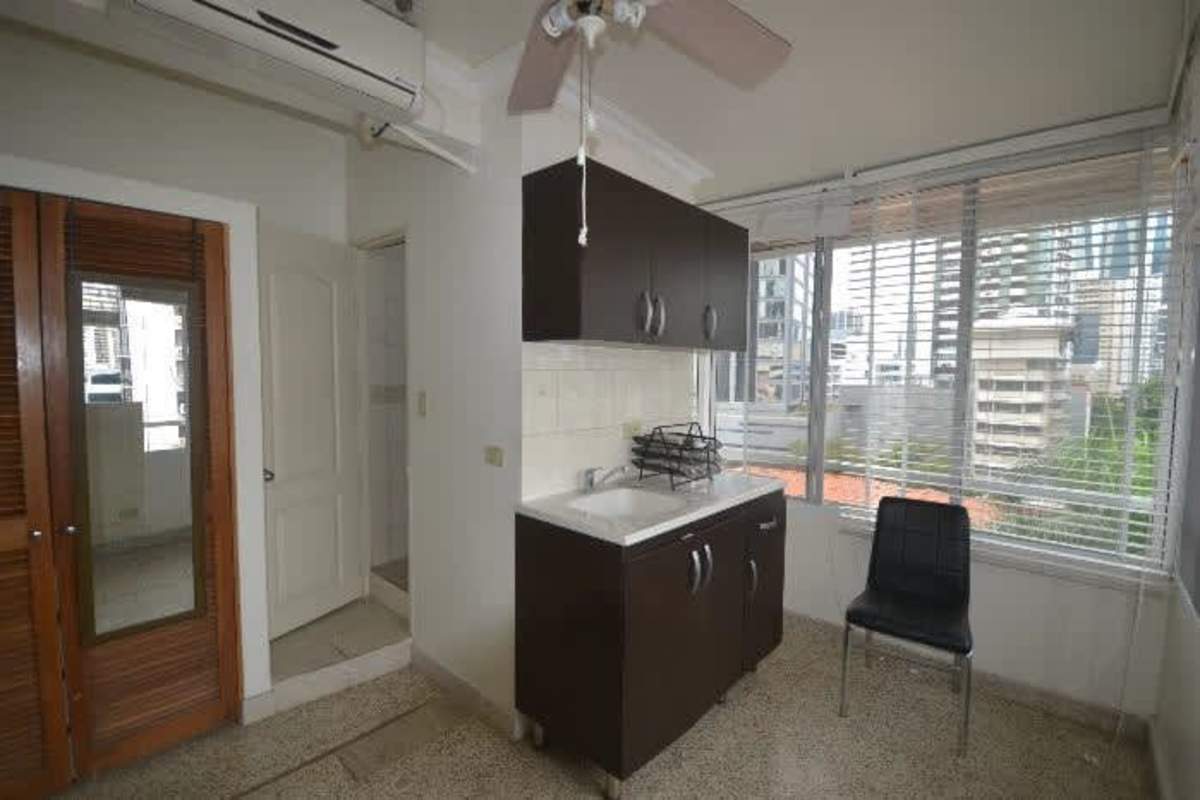 Compact kitchen with windows, cabinets, AC and ceiling fan in PH Cádiz apartments Calle 50 Panama