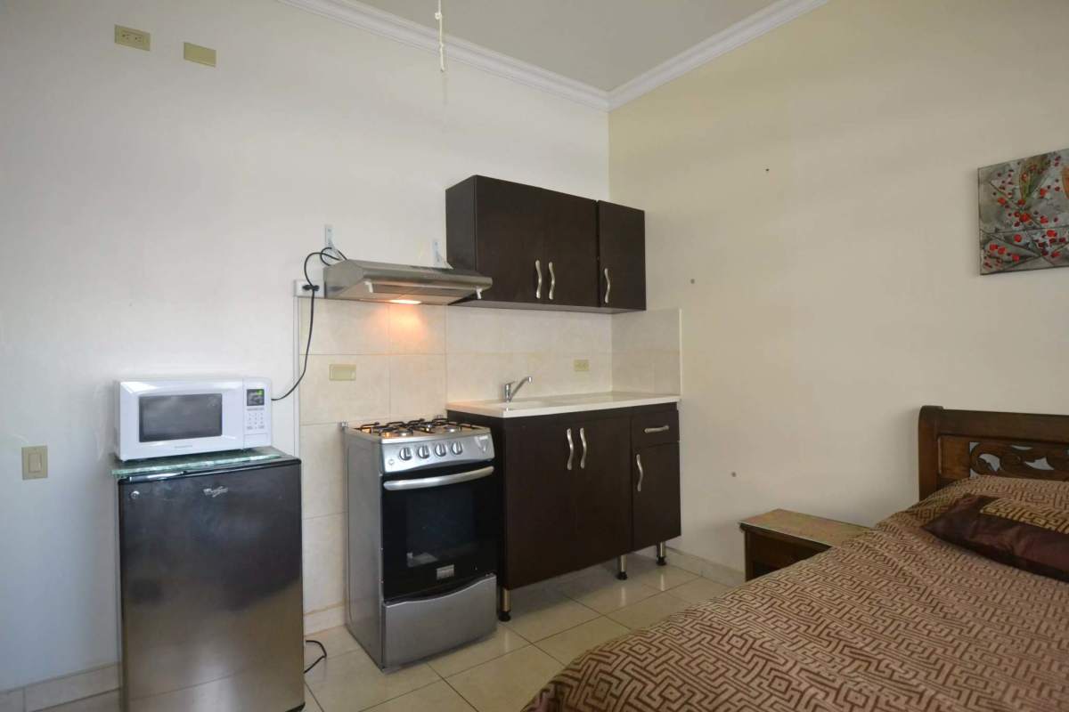 Compact kitchen, microwave, fridge and bed in studio apartment PH Cádiz Bella Vista Panama
