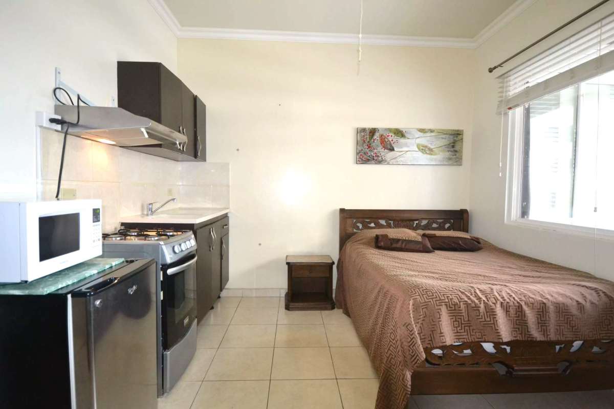 Compact studio unit with bed, kitchenette, appliances and window in PH Cádiz Calle 50 Panama