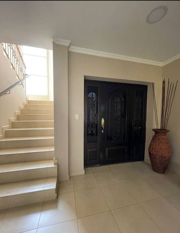 Welcoming entrance hall with natural light and staircase with arched window in PH Rainforest Villas