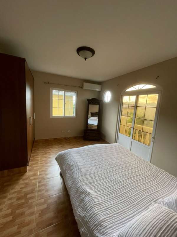 Spacious master bedroom opening to private balcony with garden view in Altos de Panama