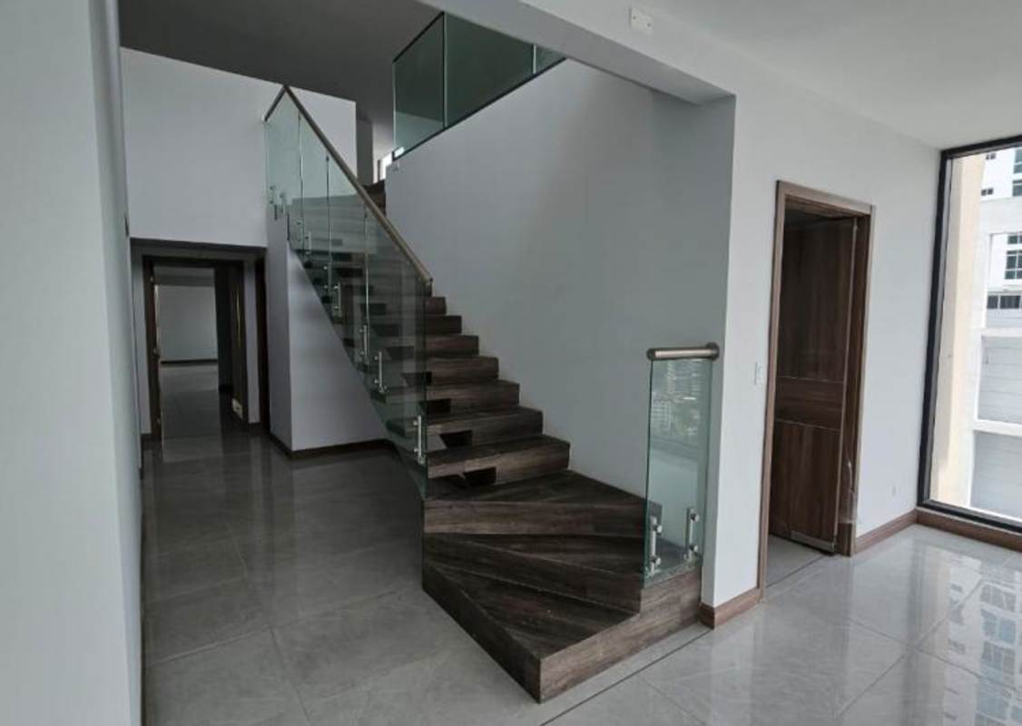 Modern duplex hall and staircase with glass railings at Prestige Bella Vista Panama