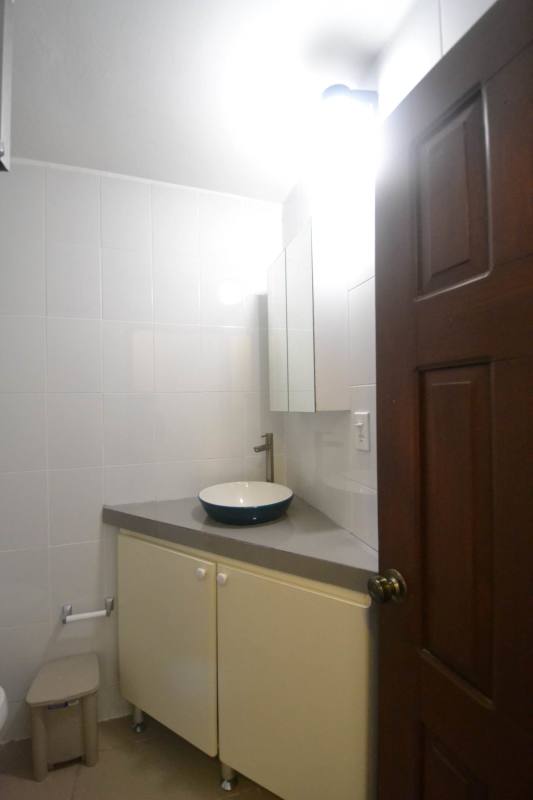 Small bathroom with vessel sink, mirror and tile walls in PH Adir studio Panama City