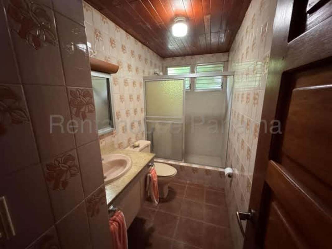 Large living dining area with wood ceiling, red tile floors and natural light in Panama Altos del Golf house