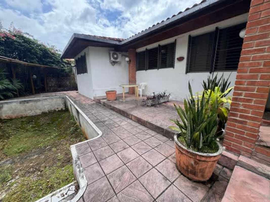 Garden backyard view with empty pool tiled deck and plants house Altos del Golf Panama