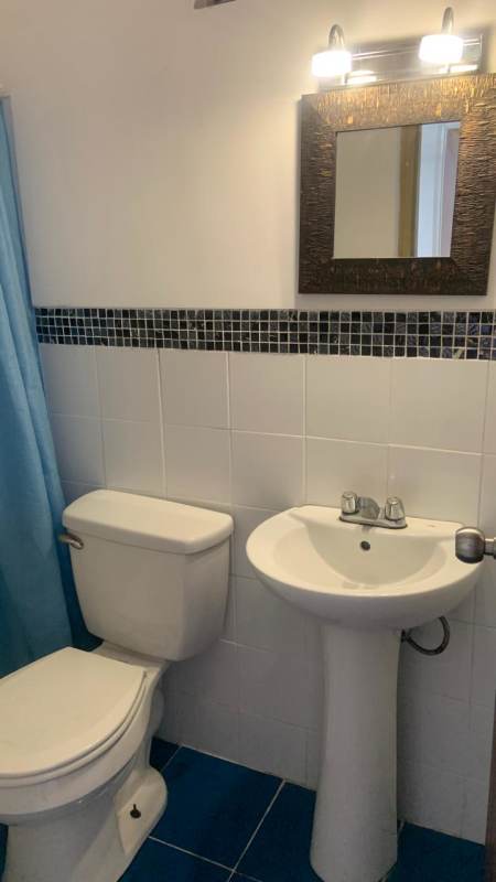 White tiled bathroom with walk-in shower at Edificio Monserrat Obarrio Panama