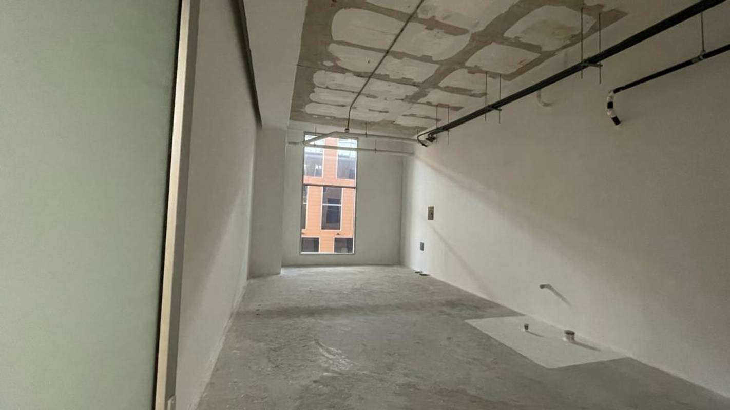 Blank unfinished commercial interior with window, exposed piping ready for new office in Costa del Este