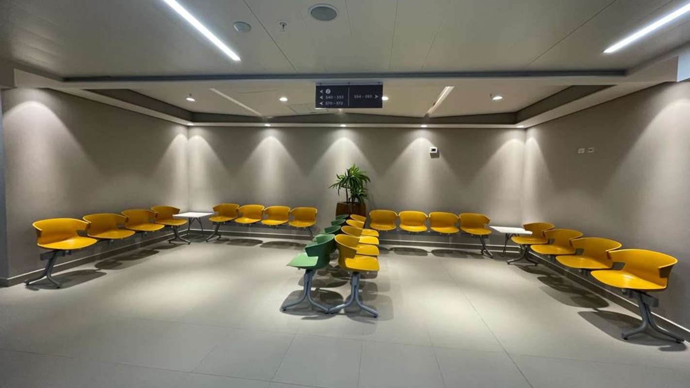Modern waiting lounge area in commercial tower with bright chairs and signage in Town Center Panama